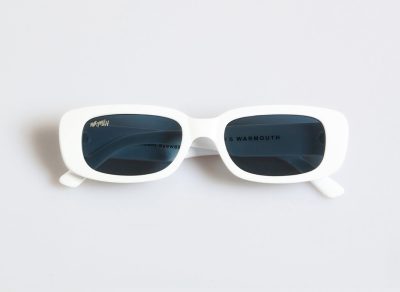 Las gafas de sol Gentleman Guy, ideales para el caballero moderno, presentan elegantes marcos blancos y lentes oscuros, sobre un fondo claro y liso.