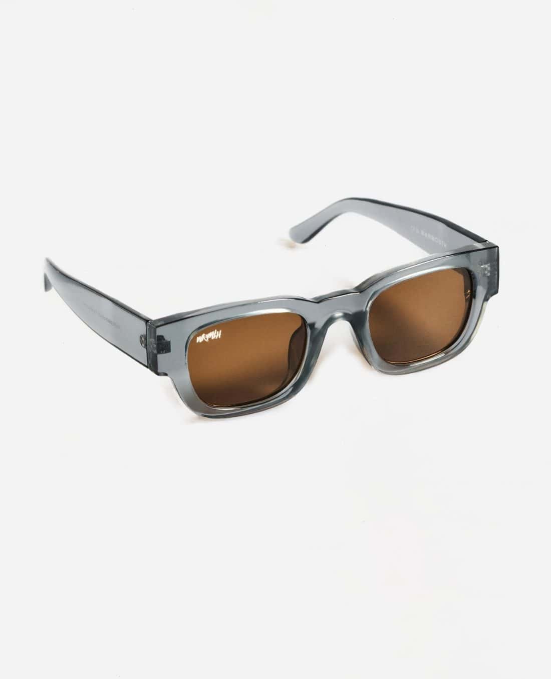Presentamos las gafas de sol Radical Roots, con elegantes monturas grises transparentes y lentes marrones. Ubicadas sobre un fondo blanco liso, estas gafas de sol muestran a la perfección su diseño elegante y sus monturas gruesas.