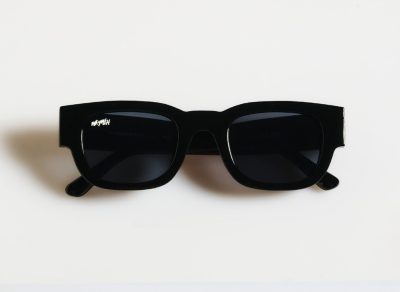 Las gafas de sol Radical Roots, con sus marcos rectangulares negros y lentes oscuros, descansan sobre un fondo blanco liso, exudando una onda radical.