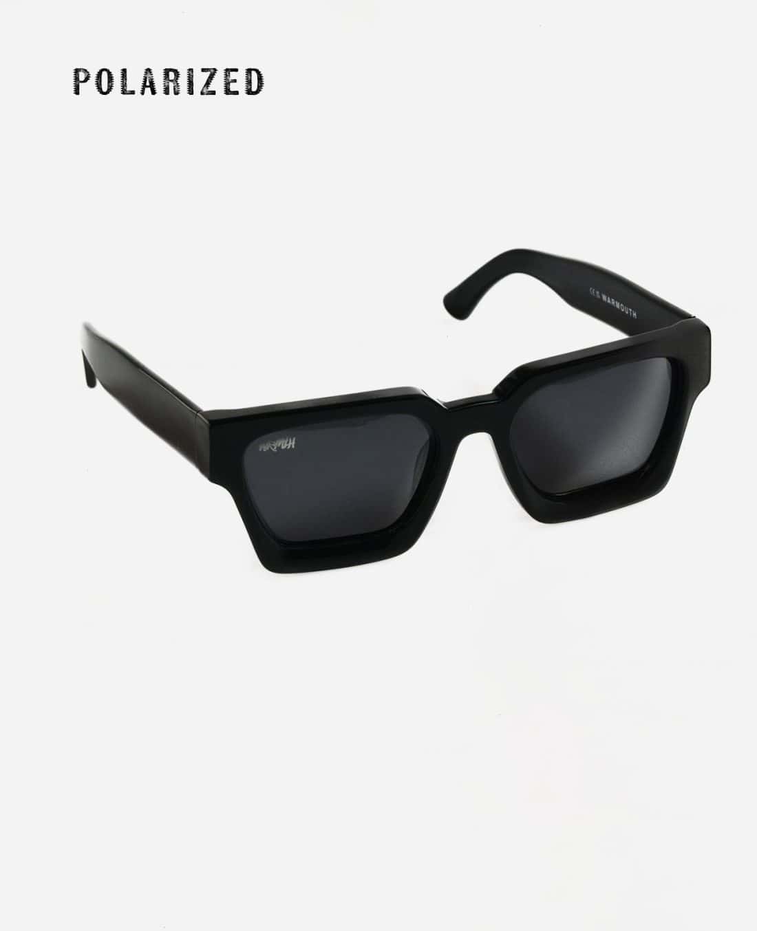 Las gafas de sol Gentleman Guy se presentan sobre un fondo blanco, con un elegante diseño rectangular negro con lentes oscuras que ofrecen un estilo atemporal para cualquier caballero. La característica destacada "POLARIZED" se muestra de forma destacada en la esquina superior izquierda, lo que enfatiza la calidad excepcional de las lentes.